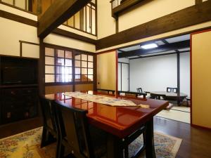 a dining room with a wooden table and chairs at Kisoji no Yado Iwaya in Kiso