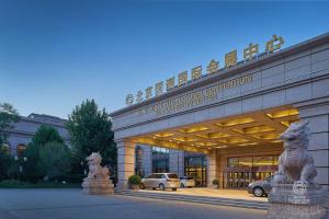 un edificio con coches estacionados frente a él en GUOCE International Convention & Exhibition Center en Shunyi