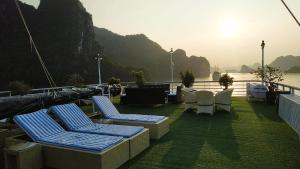 a deck with lounge chairs and a view of the water at Lotus Elegance Cruise in Ha Long