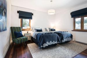 een slaapkamer met een bed en een groene stoel bij Three Paddocks in Bullarto