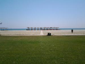 an empty beach with umbrellas and the ocean at Lidra in Korinos