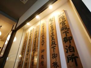 una vitrina con letreros chinos en una pared en Kisoji no Yado Iwaya en Kiso