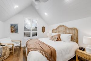 a white bedroom with a bed and a chair at Vale 194 - Newly built in McLaren Vale - 5 holiday homes with king size beds in McLaren Vale