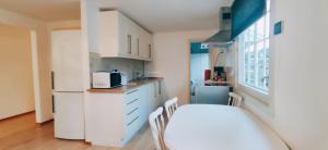 a kitchen with white cabinets and a white refrigerator at Gjestehus i Tveit in Kristiansand