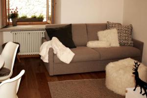 a living room with a couch with pillows and a window at NEW Alpe Veille, Chalet Centro La Thuile 2 Bagni e Garage Privato in La Thuile