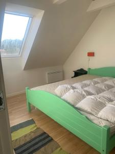 SøndersøにあるDrejerindens kreative stemningsfulde lejlighedの窓付きの部屋の緑色のベッド1台