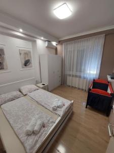 ein kleines Schlafzimmer mit 2 Betten und einem Fenster in der Unterkunft Ancora apartment Lana in Novi Sad