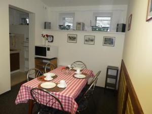 a dining room table with a red and white checkered table cloth at Apartman Flora in Benecko