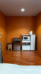 a room with a room with a microwave and a refrigerator at Rupe Rupe Lodge in Uturoa