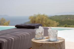 a table with two glasses on top of a table at Armante Supreme Villas-Villa Ismini in Fternón