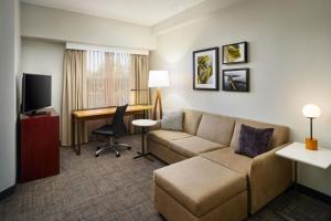 een woonkamer met een bank en een bureau in een hotelkamer bij Residence Inn Fort Lauderdale Plantation in Plantation