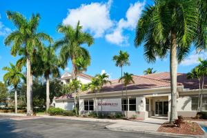 a building with palm trees in front of it at Residence Inn by Marriott Fort Lauderdale City of Plantation in Plantation
