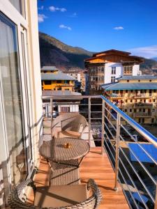 a balcony with two chairs and a table on a building at Nirvana Inn in Paro