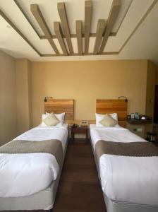 Postel nebo postele na pokoji v ubytování Nirvana Inn