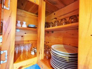 un armario de madera con platos y vasos. en Necran Bungalow اكواخ ايدر, en Rize