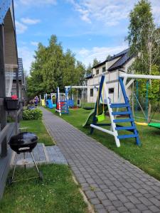 a playground with a slide and swings at Szum Fal in Rusinowo