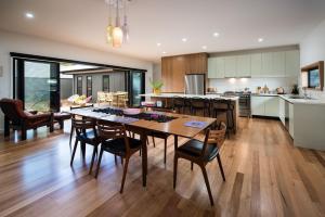 a kitchen and dining room with a table and chairs at Wombat Hill Lodge in Daylesford