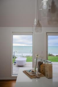 La salle de bains est pourvue d'une baignoire et offre une vue sur l'océan. dans l'établissement MOKAU BEACH HOUSE, à Mokau