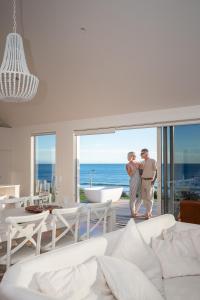 Ein Mann und eine Frau stehen in einem Wohnzimmer mit einer Badewanne in der Unterkunft MOKAU BEACH HOUSE in Mokau