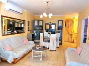 a living room with two couches and a table at Anthi Apartment in Paleo Tsifliki
