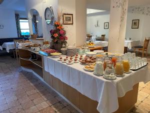 una mesa buffet con comida y bebidas. en Pension Angelo, en Corvara in Badia