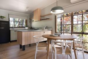 a kitchen and dining room with a table and chairs at Wood for the Trees in Hepburn Springs