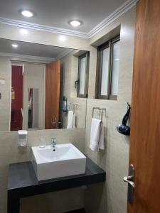 a bathroom with a sink and a large mirror at Hotel Stella Talca in Talca