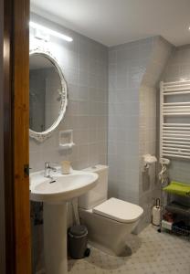 ein Badezimmer mit einem Waschbecken, einem WC und einem Spiegel in der Unterkunft Ca l'Ametller in Torregrosa