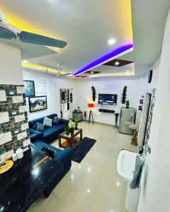 een woonkamer met een blauwe bank en een tv bij Light House, Unique & Cozy 2bhk in Guwahati