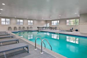 a large swimming pool with tables and chairs in a building at Residence Inn Wayne in Wayne