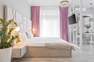 1 dormitorio con 1 cama grande y cortinas rosas en Andreea Studio, en Oradea
