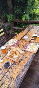 una mesa de madera con diferentes tipos de comida. en Cottage 1600 Bosaca en Nikšić