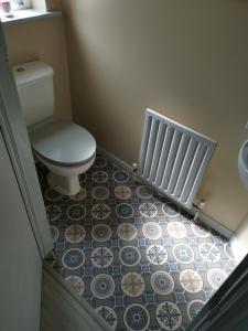a bathroom with a toilet and a radiator at Lewis Square Town House in Belfast