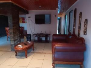 sala de estar con sofá de cuero y mesa en Cómoda casa con piscina en Arica