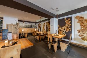 a restaurant with wooden tables and chairs in a room at Hotel Faloria in Moena