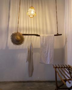 a towel rack with a light and a hanging robe at Kirãmam Villa in Pasikuda