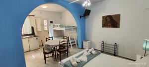 a room with a bed and a table and a kitchen at Apanemia Rooms in Kini