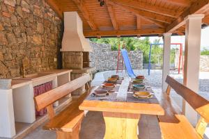 a wooden table with dishes on it in a kitchen at Villa Danica with pool - Perka in Zvoneće