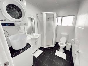 a white bathroom with a sink and a toilet at Gem 7 Gladstone Apts - Suva CBD 2bdrm in Suva