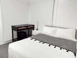 a bedroom with a bed with a black and white comforter at Gladstone Gem 7 - Suva CBD 2bdrm Apartment in Suva