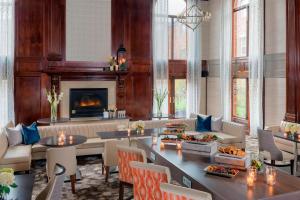 sala de estar con chimenea, mesas y sillas en Residence Inn by Marriott West Orange en West Orange