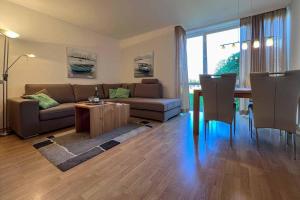 sala de estar con sofá y mesa en Ferienwohnung-9-mit-Schwimmbad-Sauna-Residenz-Passat-Doese, en Cuxhaven