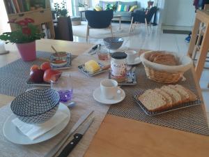 a table with a breakfast of bread and food at Chambre d'hôte cosy & zen in Saint-Jean-la-Poterie