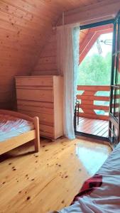 a room with a bed and a window in a cabin at Borowa Chatka in Borowy Młyn