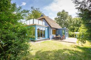 Ce petit cottage bleu dispose d'un toit de chaume. dans l'établissement Haus Traudi, à Ahrenshoop