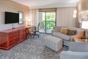 a living room with a couch and a tv at Courtyard by Marriot Cranbury South Brunswick in Cranbury