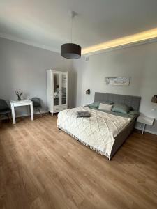 sypialnia z dużym łóżkiem i drewnianą podłogą w obiekcie Brama Krakowska - Old Town - Premium Apartment w mieście Lublin