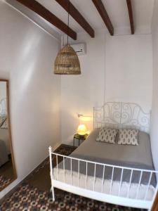 sypialnia z białym łóżkiem i lampką w obiekcie Bienvenido a Chez Matu w mieście Capdepera