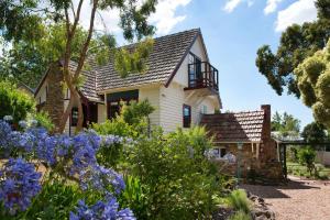 a house with flowers in front of it at Zelman Cottage in Hepburn Springs