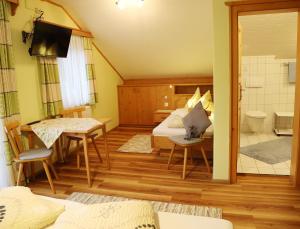 una camera con letto e tavolo e un bagno di Haufhof-Pension am Bauernhof, Haus im Ennstal bei Schladming a Haus im Ennstal